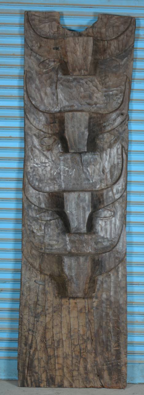 Wooden totem pole against a blue background