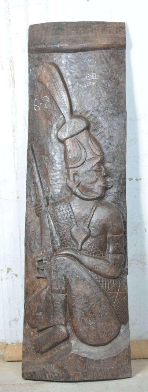 Carved wooden panel with an intricate design of a warrior holding a spear on a white background