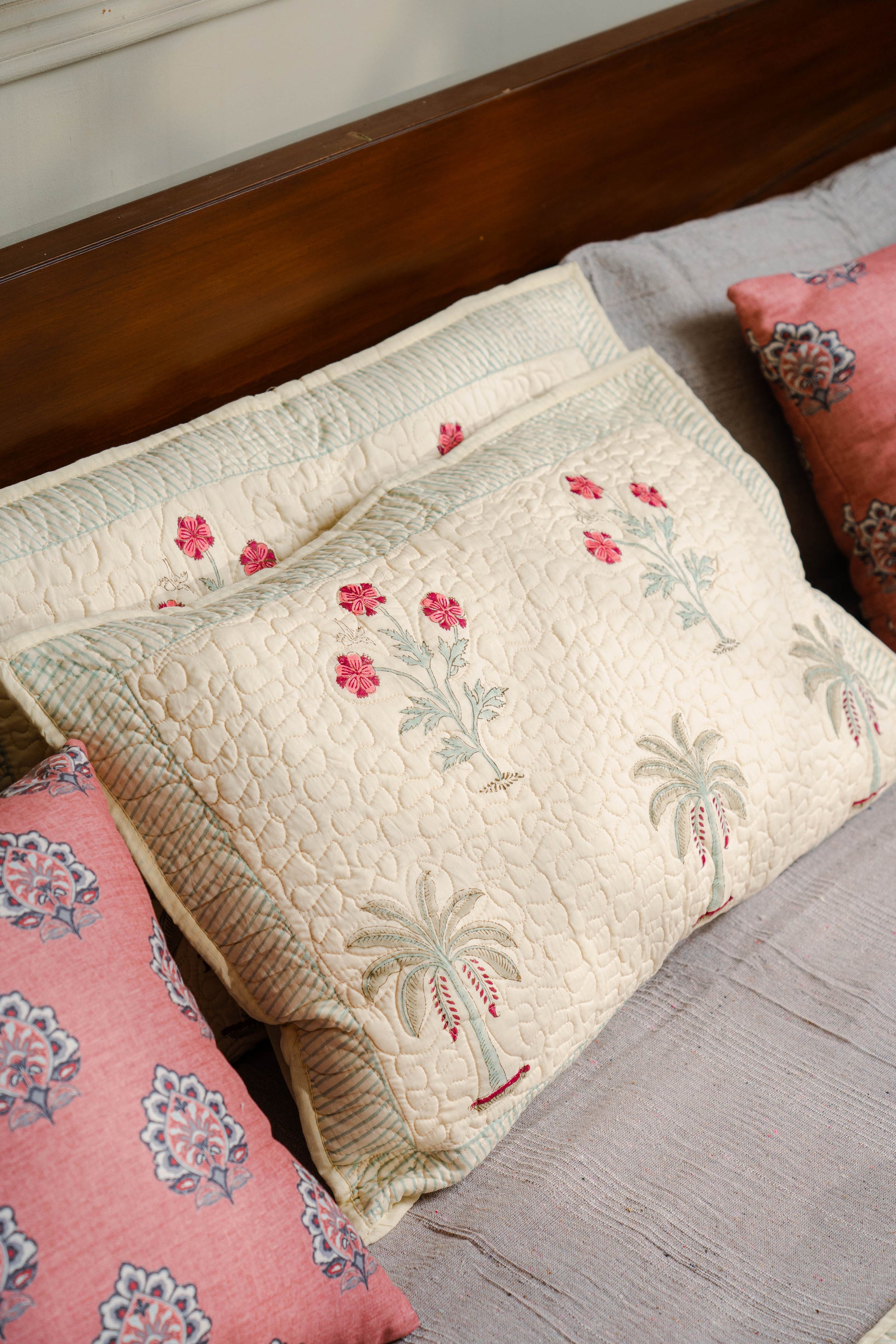 Decorative pillows with floral patterns on a bed