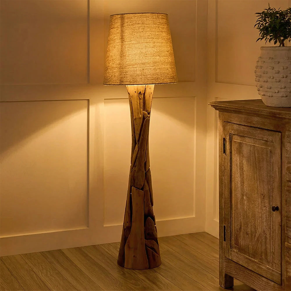 Wooden floor lamp with a textured shade in a room setting.
