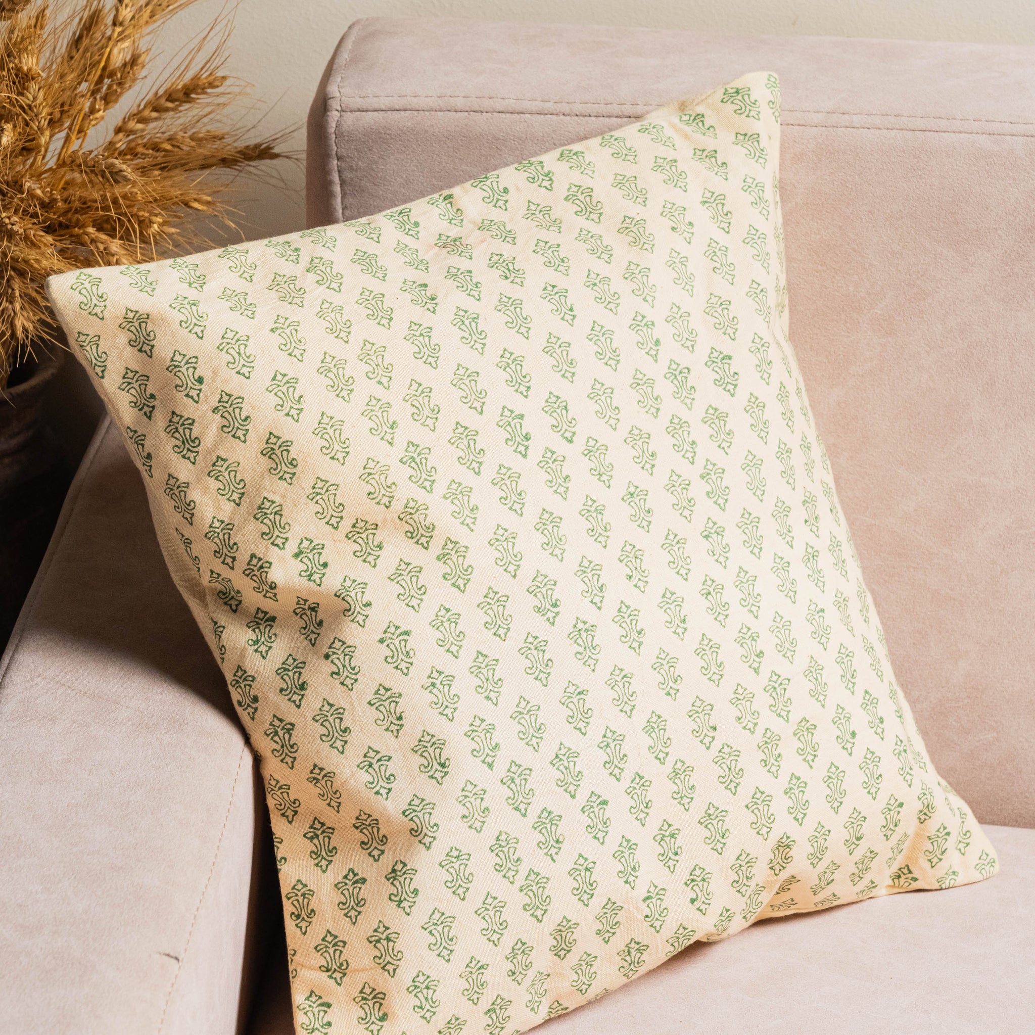 Decorative pillow with green pattern on a beige sofa