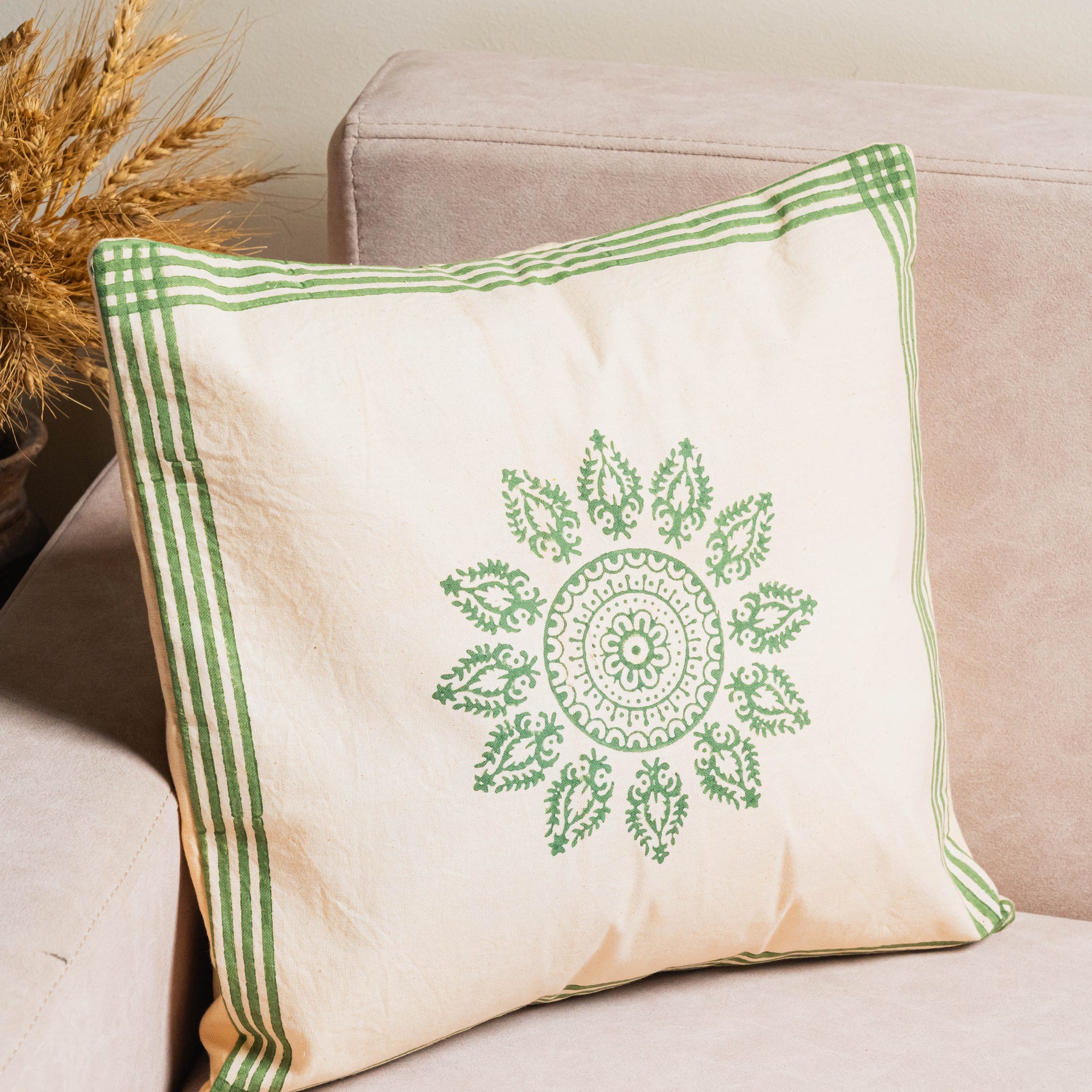 Decorative pillow with green pattern on a beige couch
