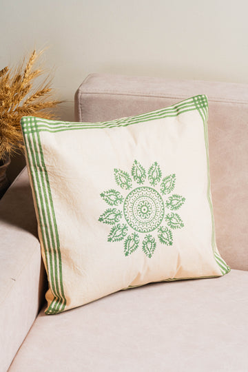 Decorative pillow with green pattern on a beige couch