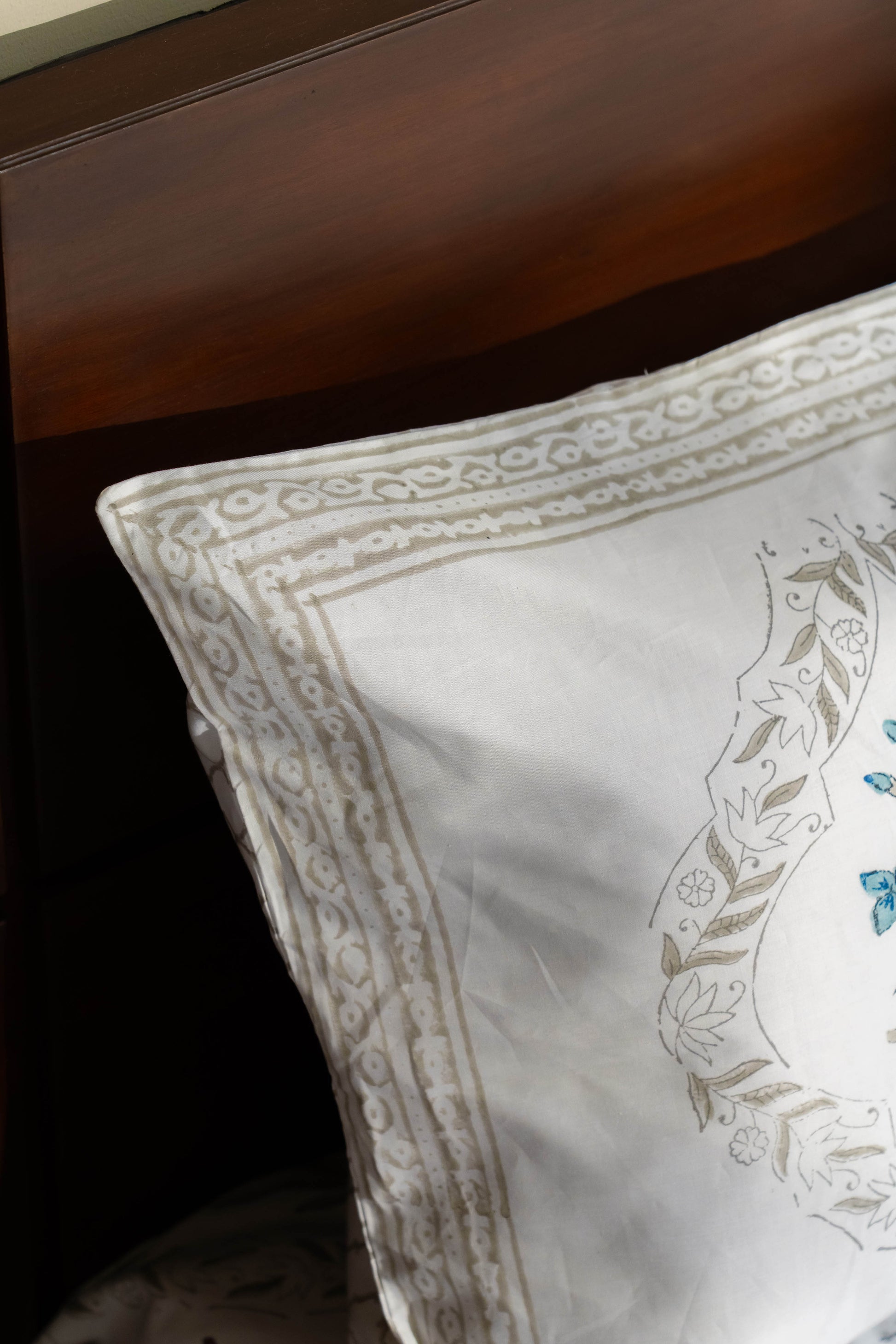 Decorative pillow with intricate patterns on a wooden surface