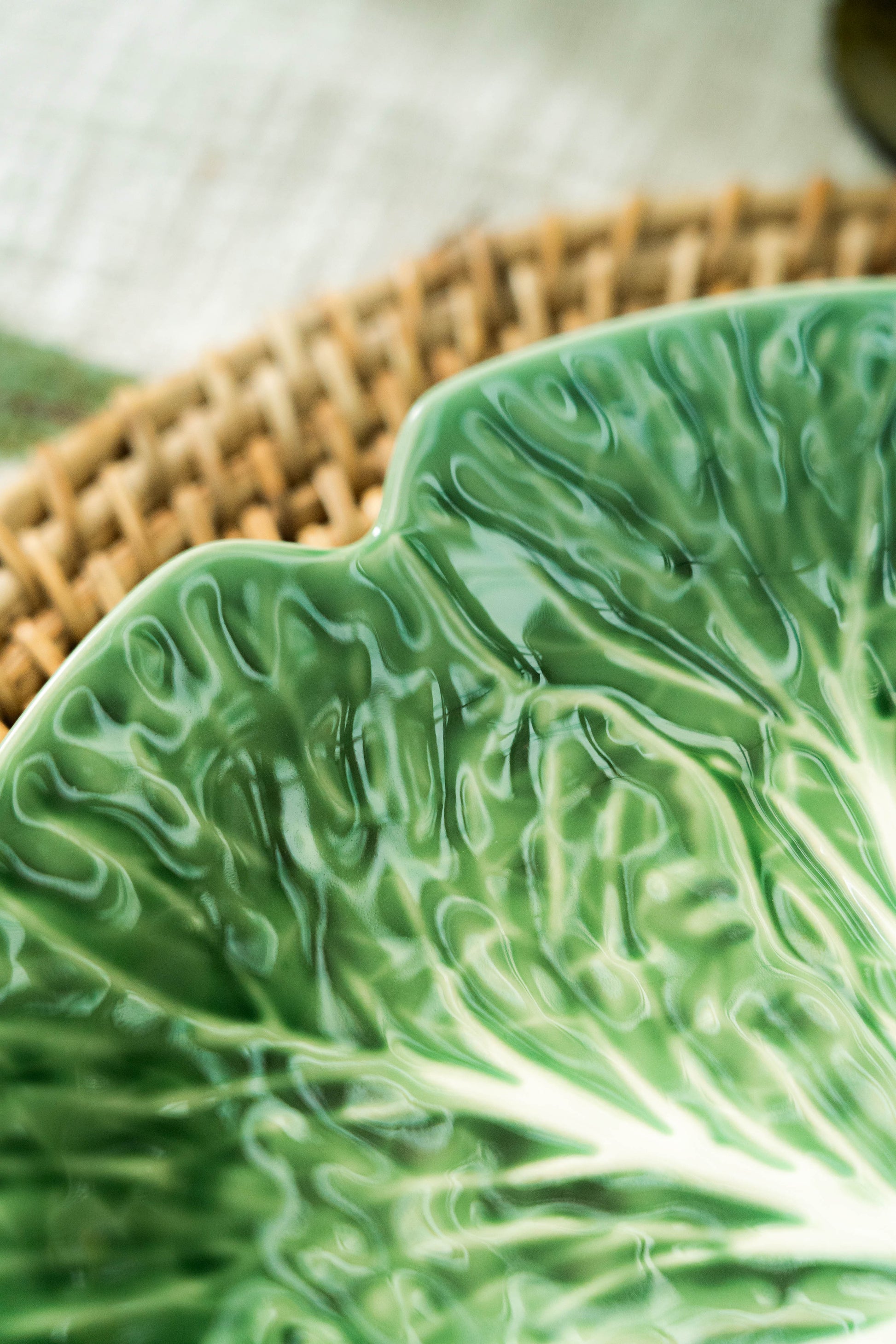 Green ceramic leaf-shaped plate on a woven mat