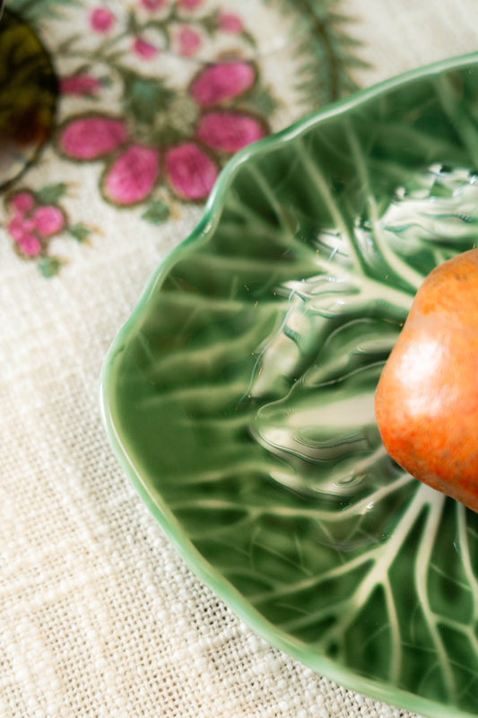 Green decorative plate with a floral pattern on a textured surface