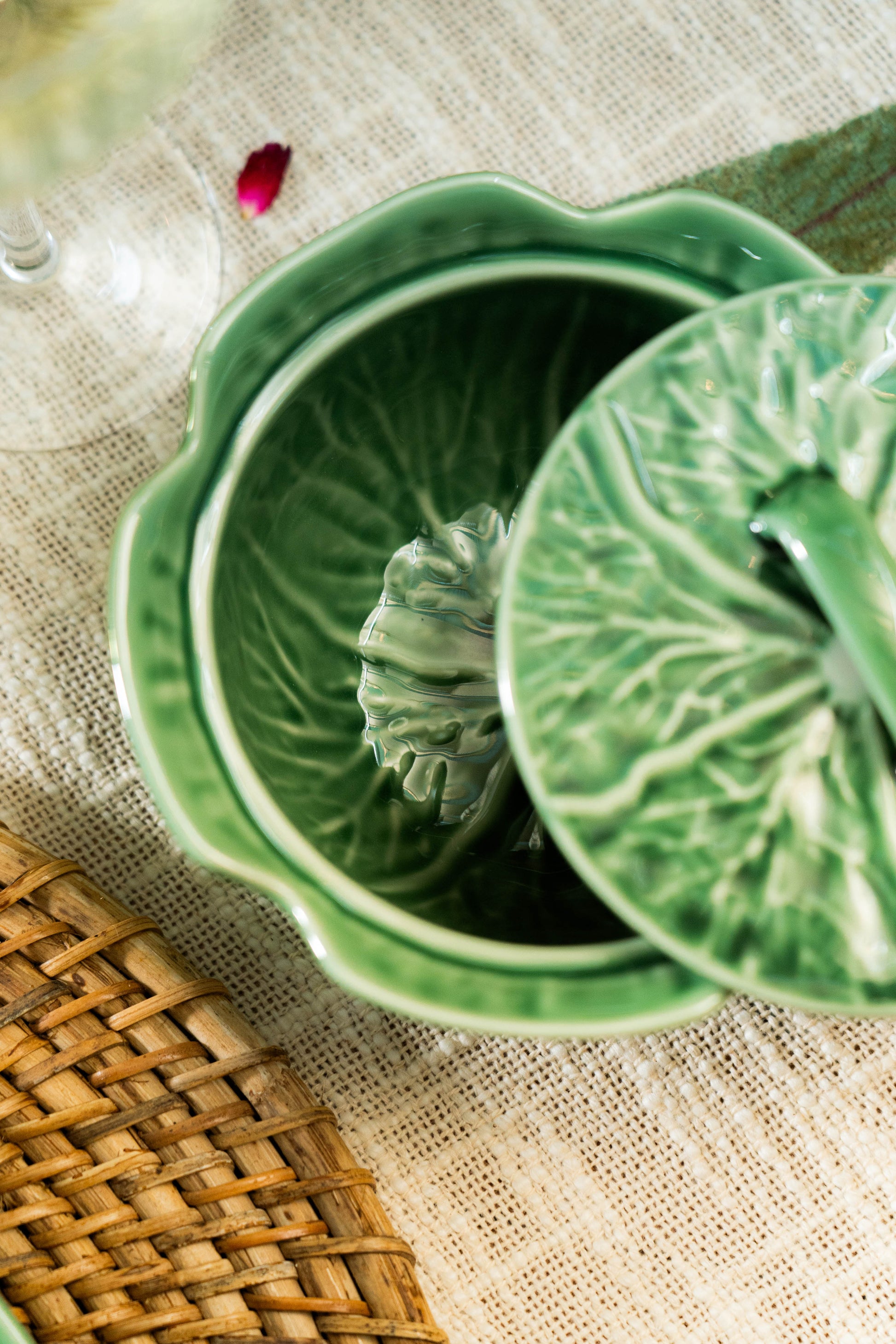 Green ceramic container with leaf design on a textured surface