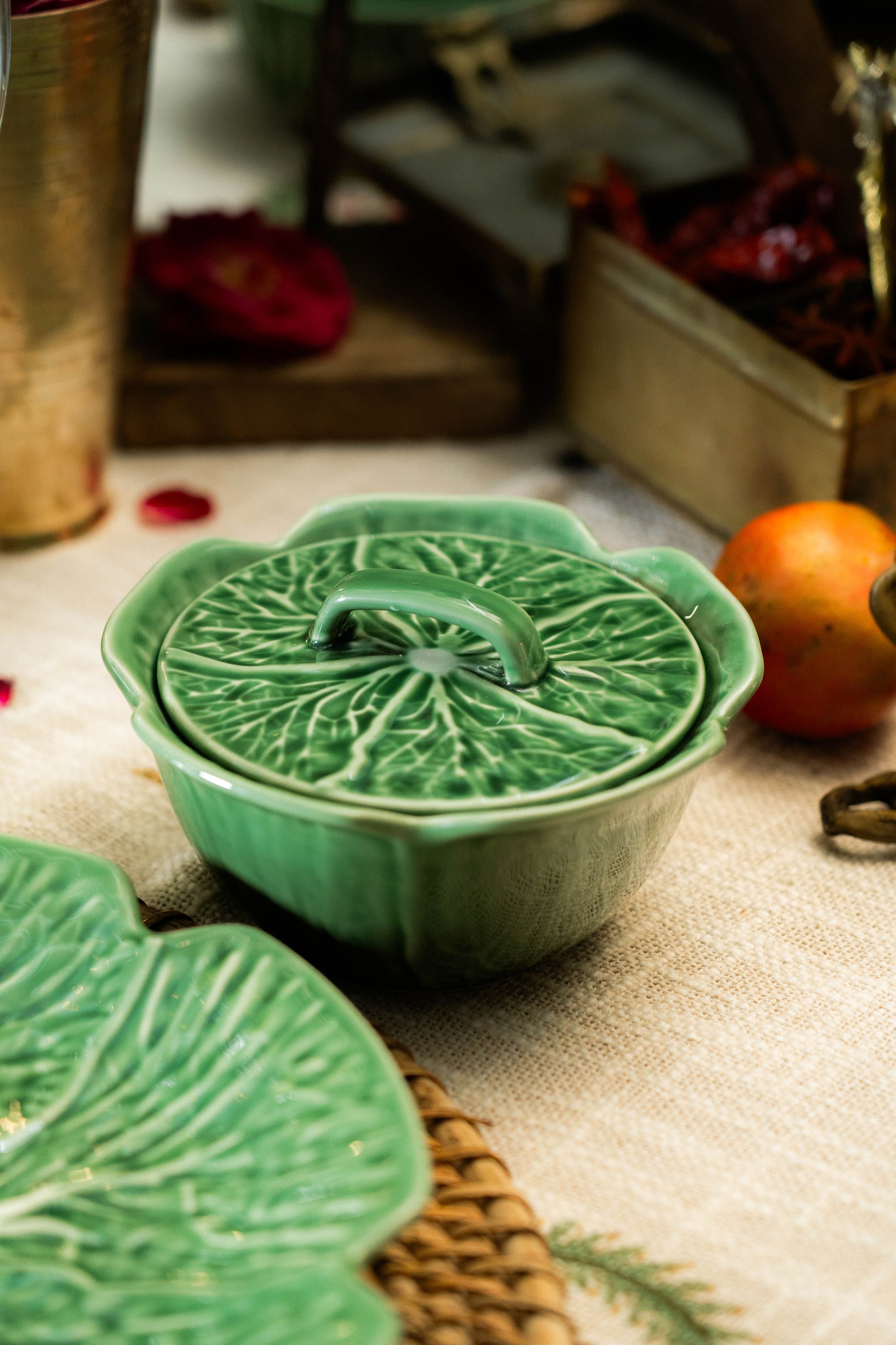 Green ceramic dish with lid on a textured surface