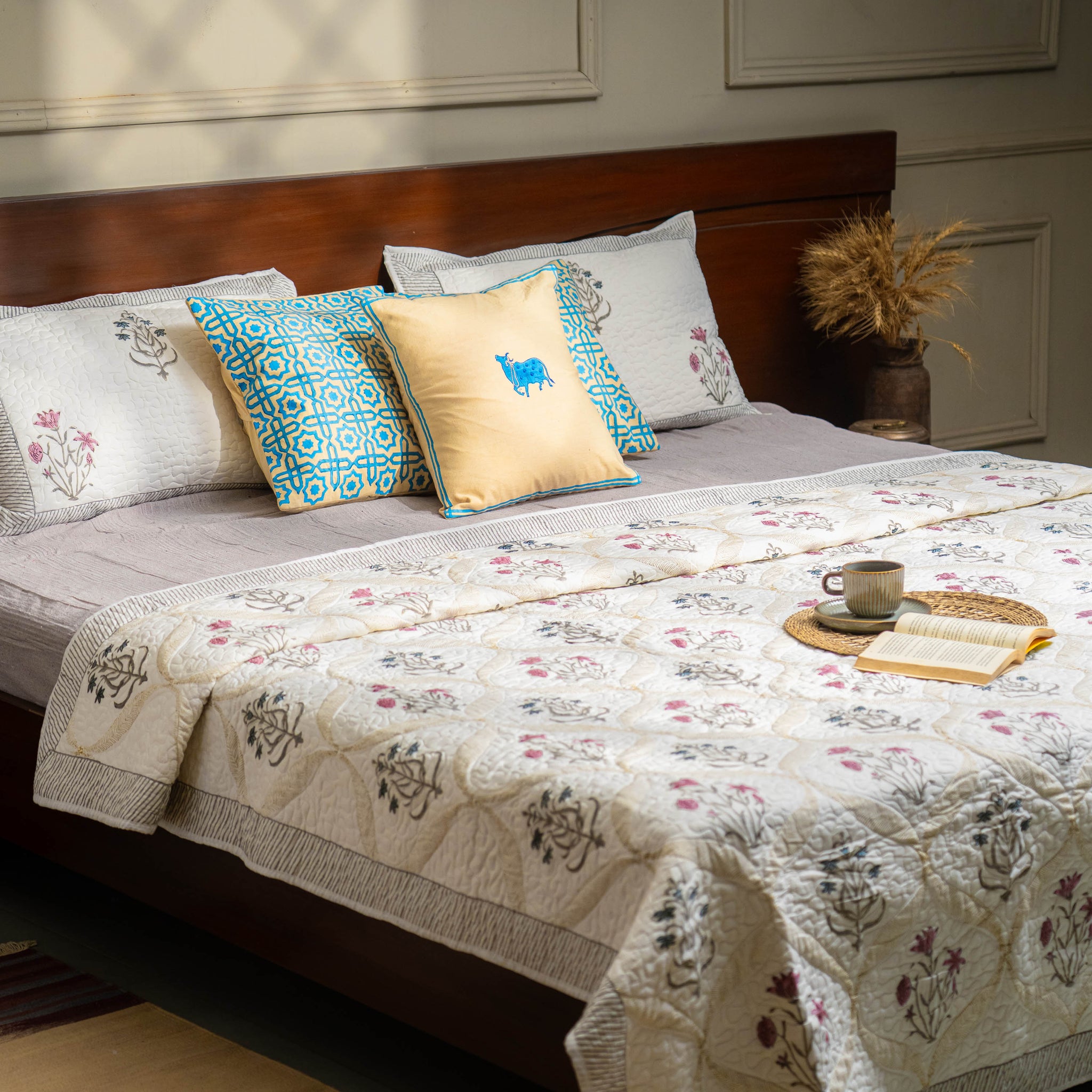 Bedroom with a bed featuring floral bedding and decorative pillows.