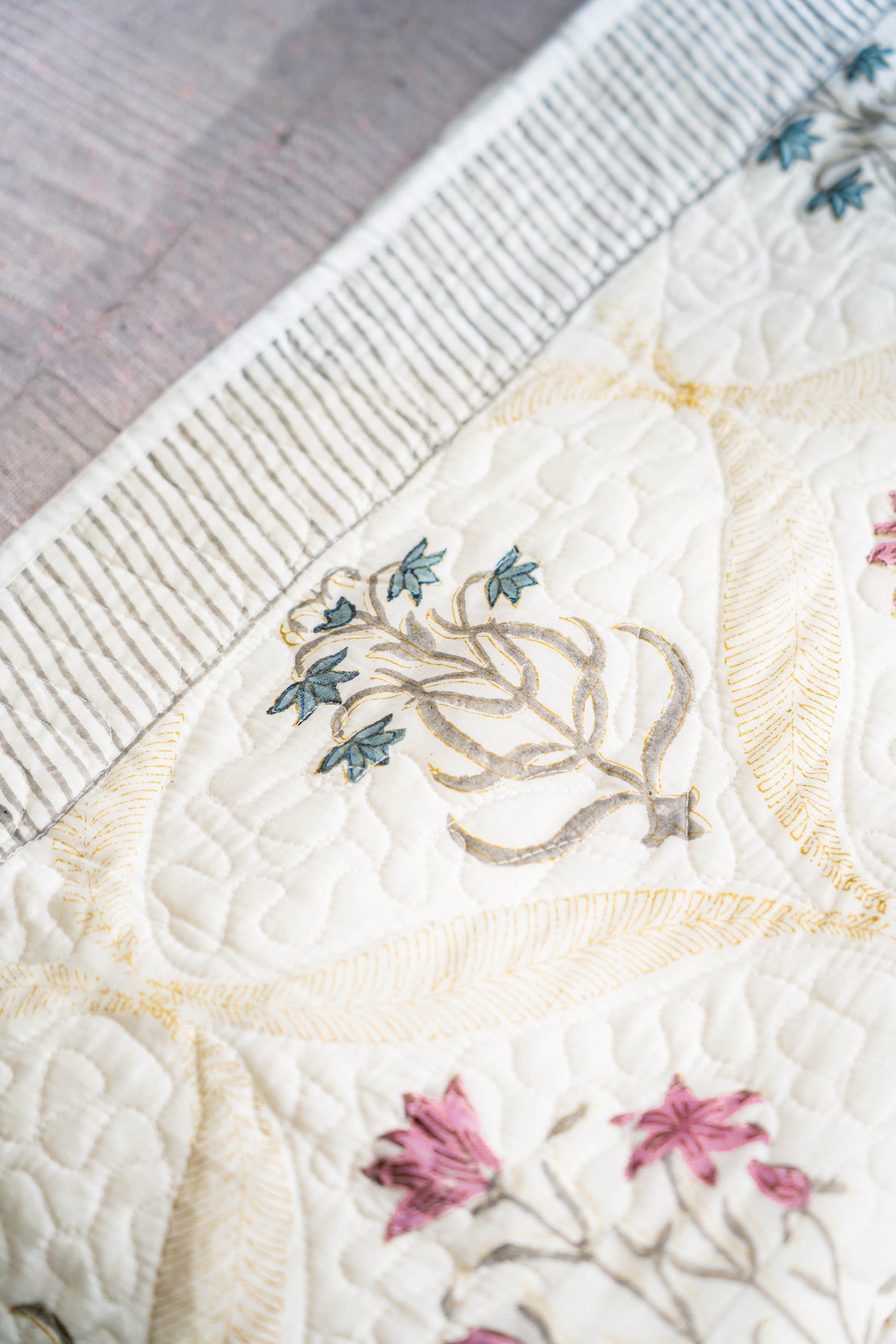 Close-up of a quilt with floral embroidery on a textured surface