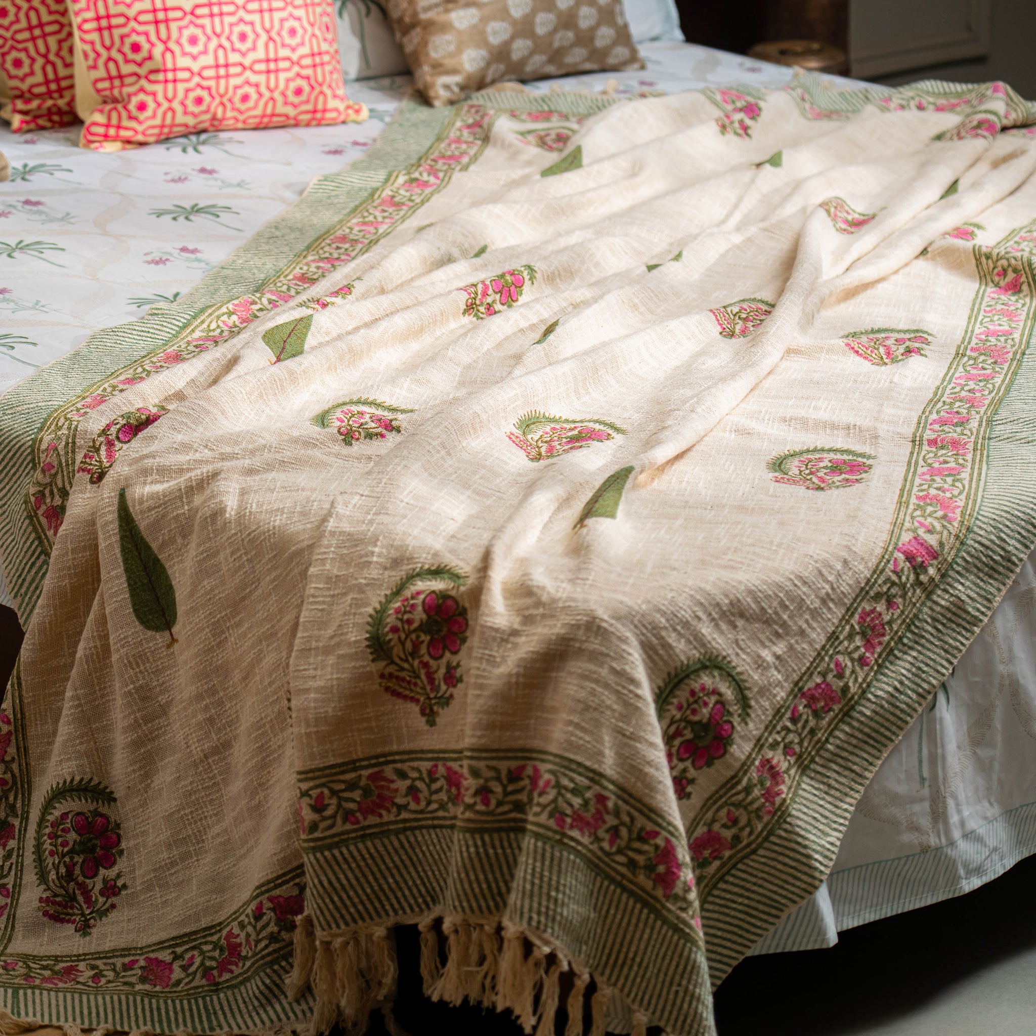 Bed with patterned bedding and pillows in a bedroom setting