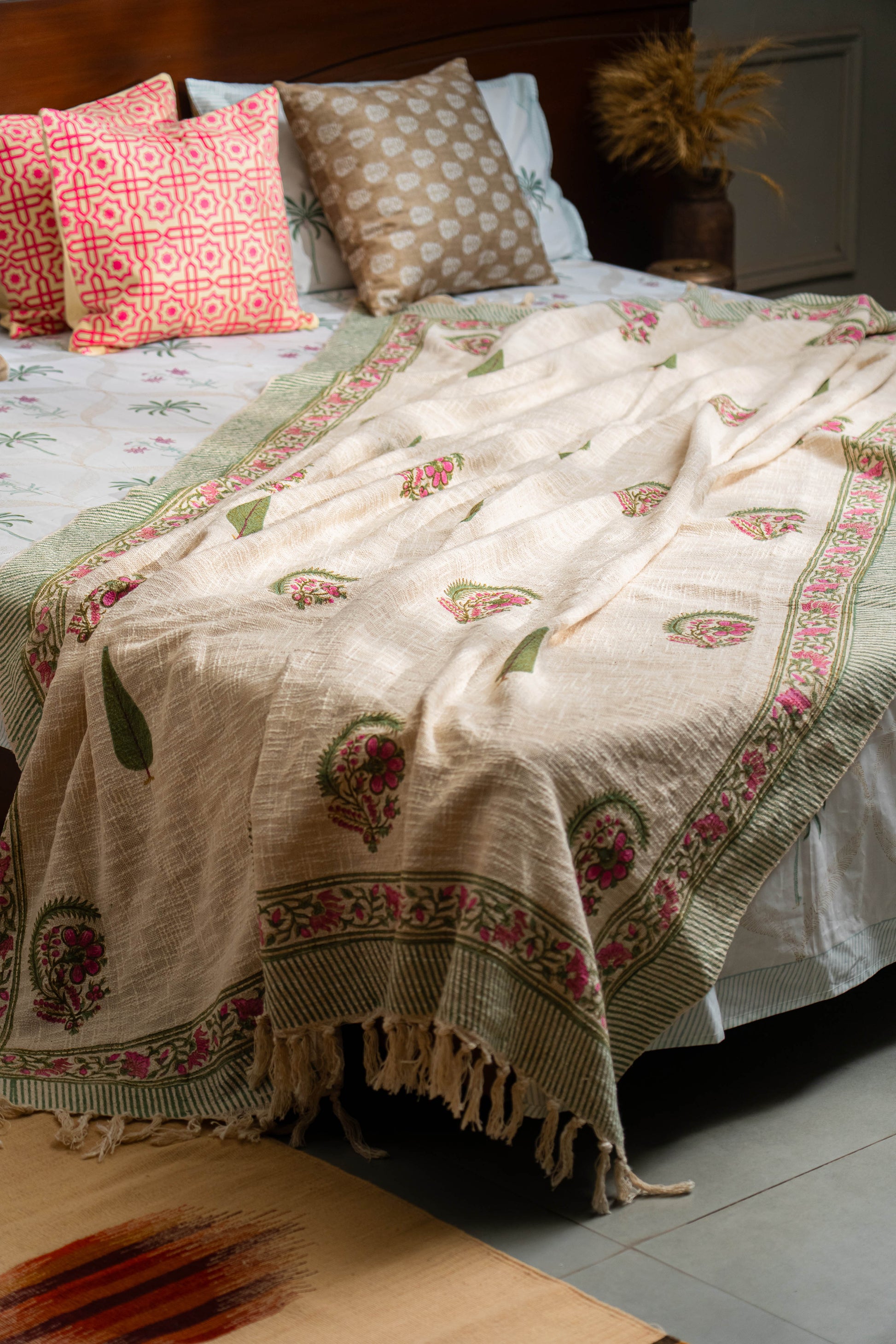 Bed with patterned bedding and pillows in a bedroom setting