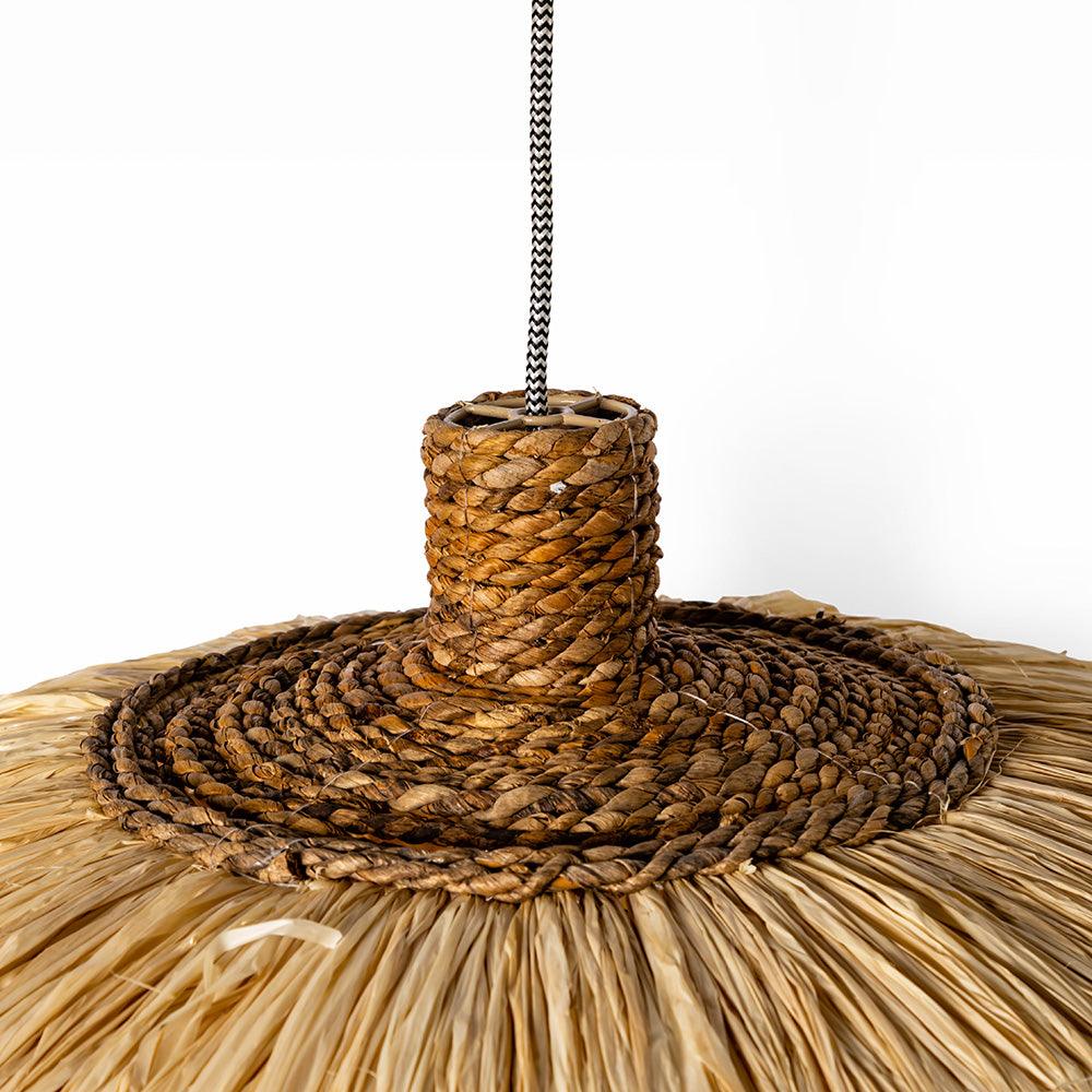 Close-up of a woven rattan lampshade with a metal chain on a white background