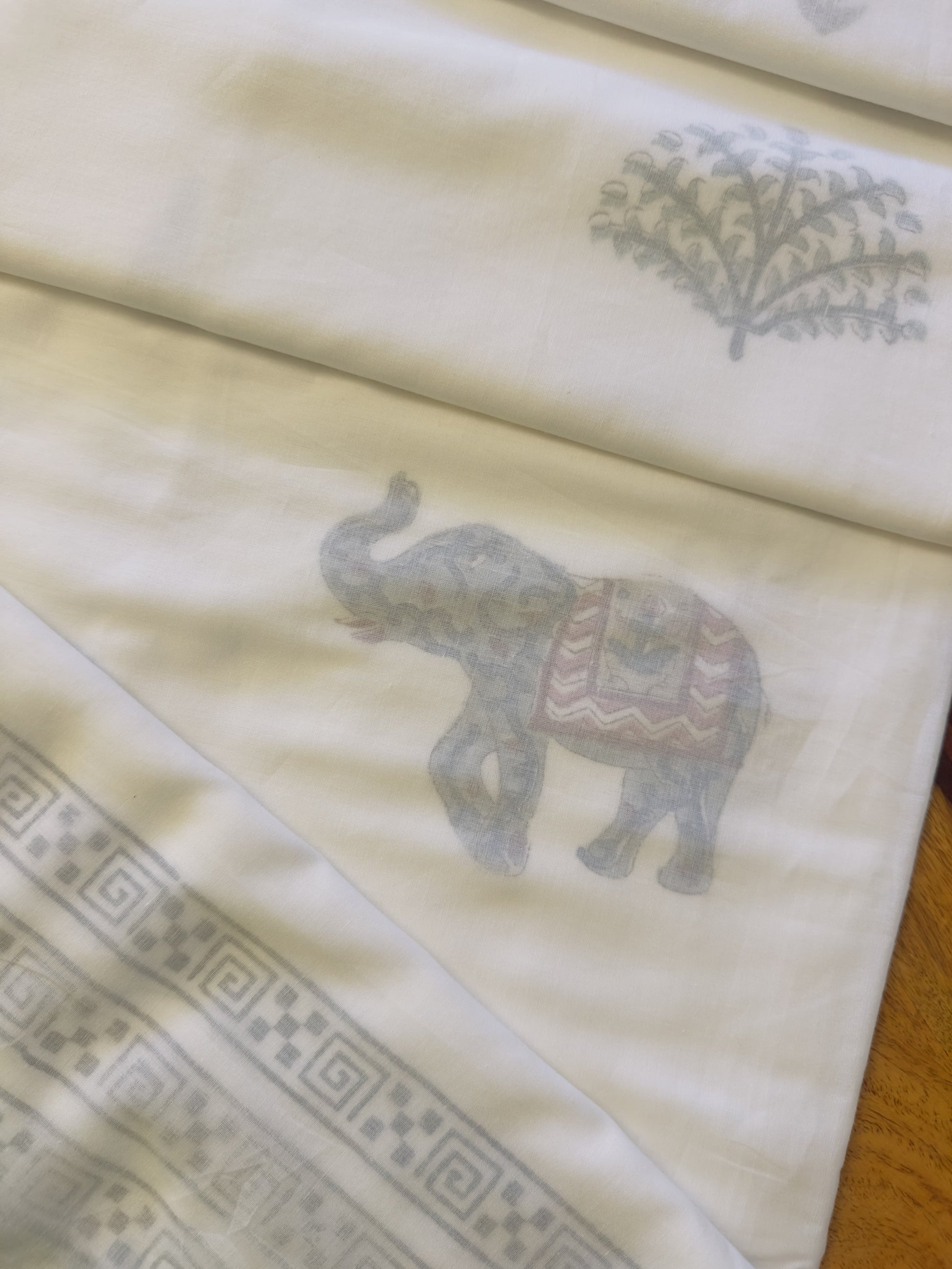 Embroidered fabric with elephant design on a beige background