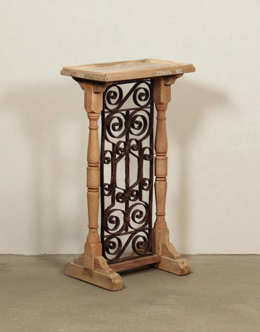 A charming blend of rustic grace and vintage craftsmanship, the Rustika Pedestal Table is a striking accent piece crafted from solid teak wood and intricate ironwork. 