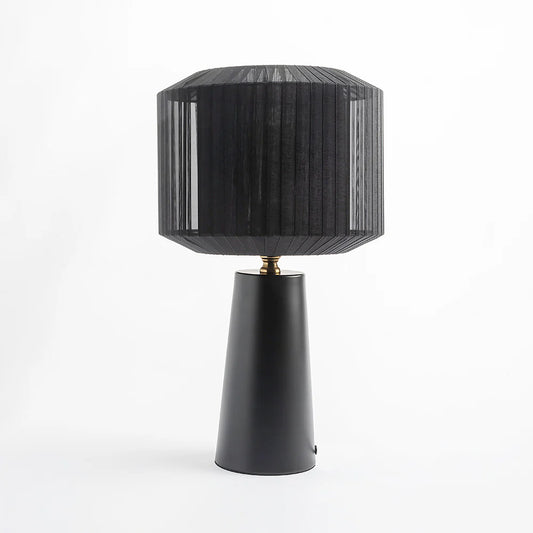  Featuring a sleek metal base and a sculptural ribbon-wrapped shade, 