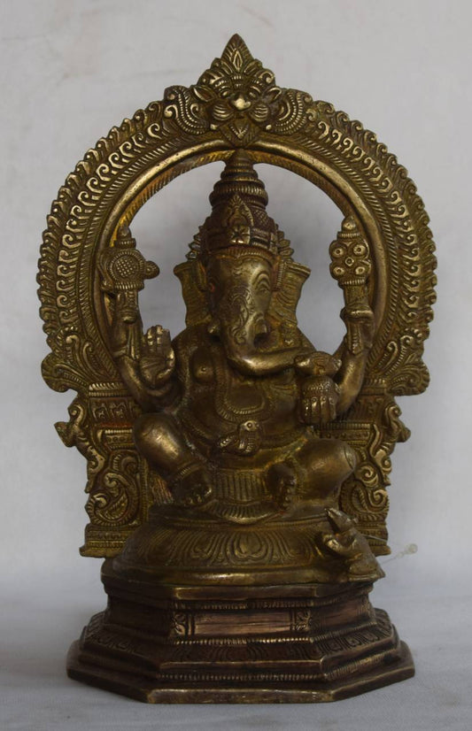 Handcrafted from solid brass, this idol features Lord Ganesha seated in a traditional posture with rich detailing, set within a beautifully arched ornamental frame.