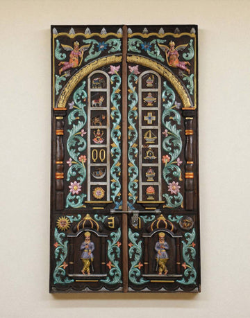 The panel features two guardian figures at the base, believed to be protectors of sacred thresholds, flanked by blooming floral motifs and flowing vines.
