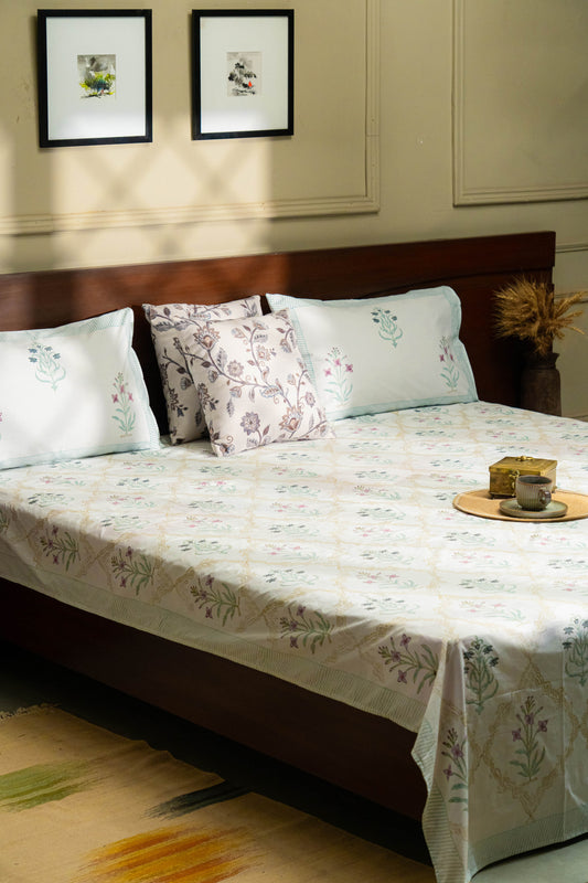 Bedroom with a bed featuring floral bedding and pillows, wooden headboard, and framed pictures on the wall.