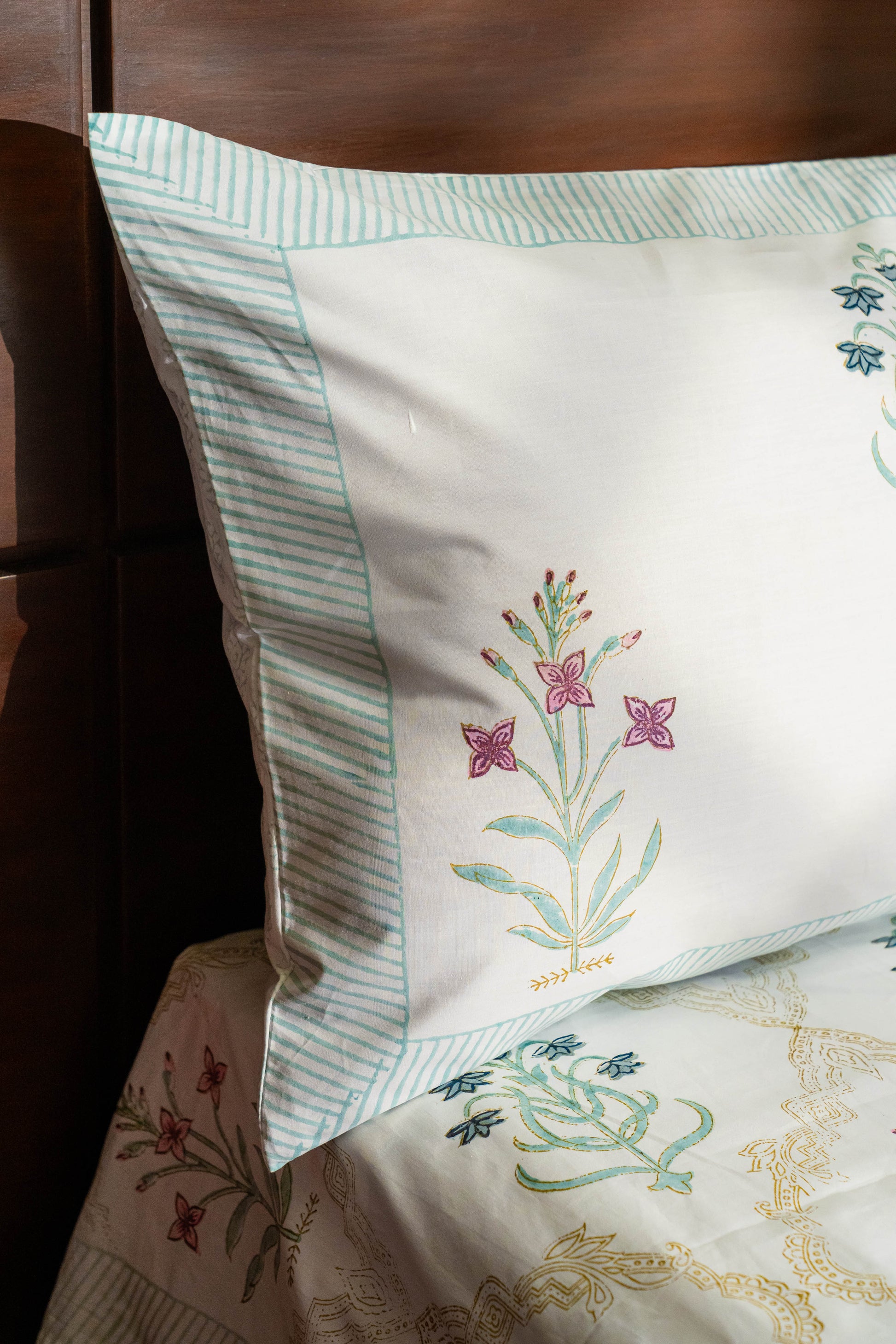 Embroidered pillow with floral design on a bed