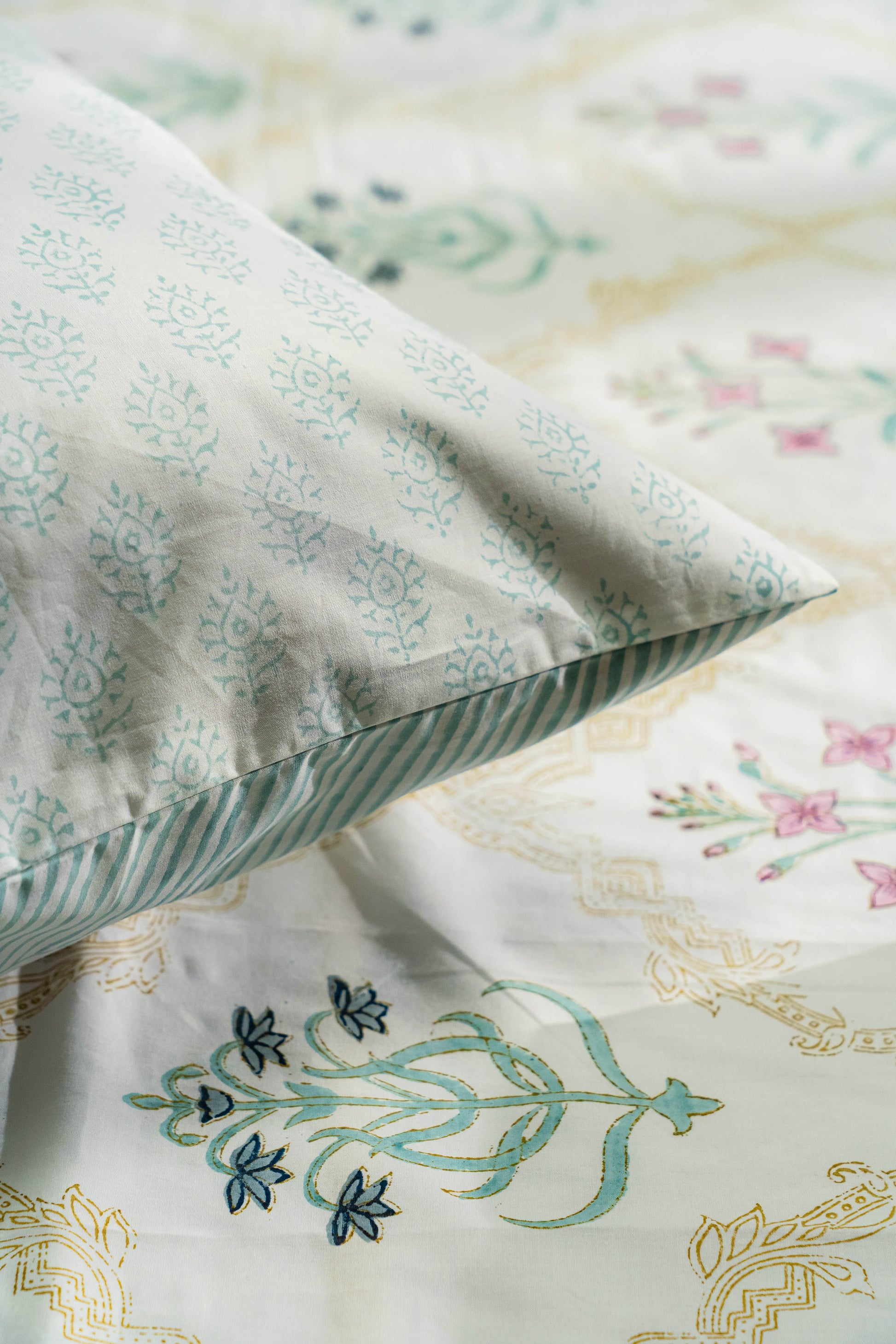 Floral patterned pillow and bedding with intricate designs on a soft background