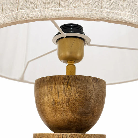 Close-up of a lamp with wooden base and white shade on a white background