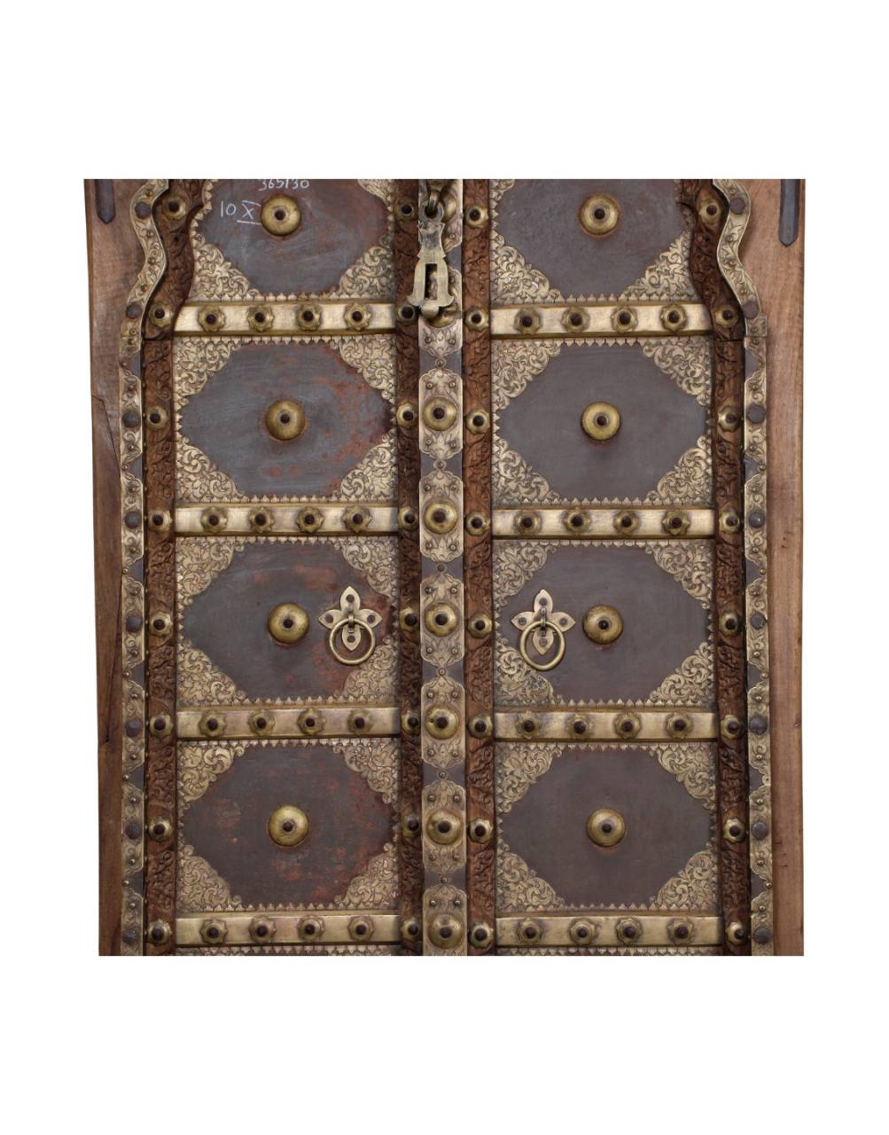 A close-up of an ornate vintage wooden door with decorative metal panels, brass studs, a keyhole, and circular door pulls.