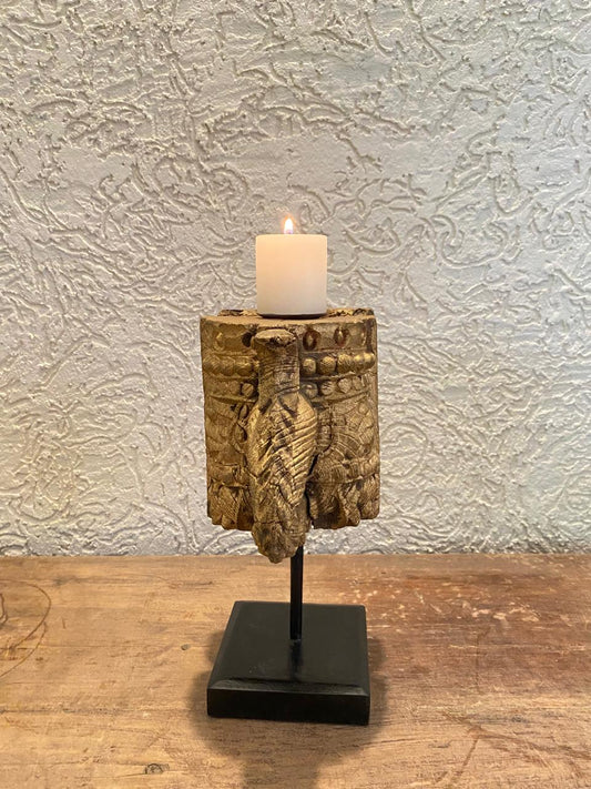 Decorative candle holder with a textured design on a wooden surface and light gray wall background