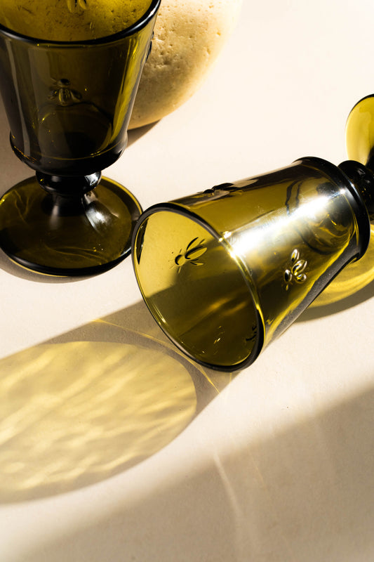 Green glass bottle and goblet on a light background