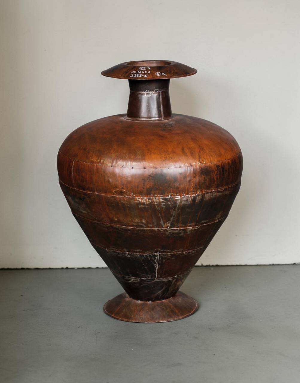 Large brown ceramic vase on a gray surface with a white background