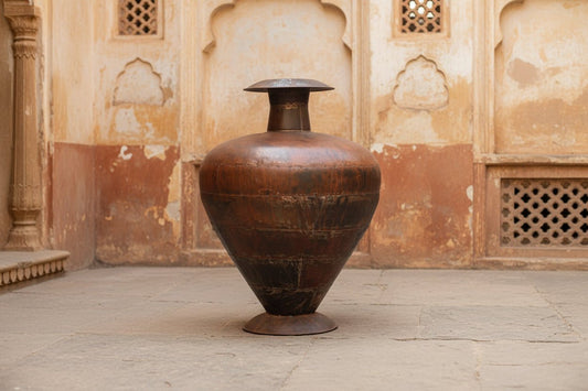 Large brown ceramic vase on a gray surface with a white background