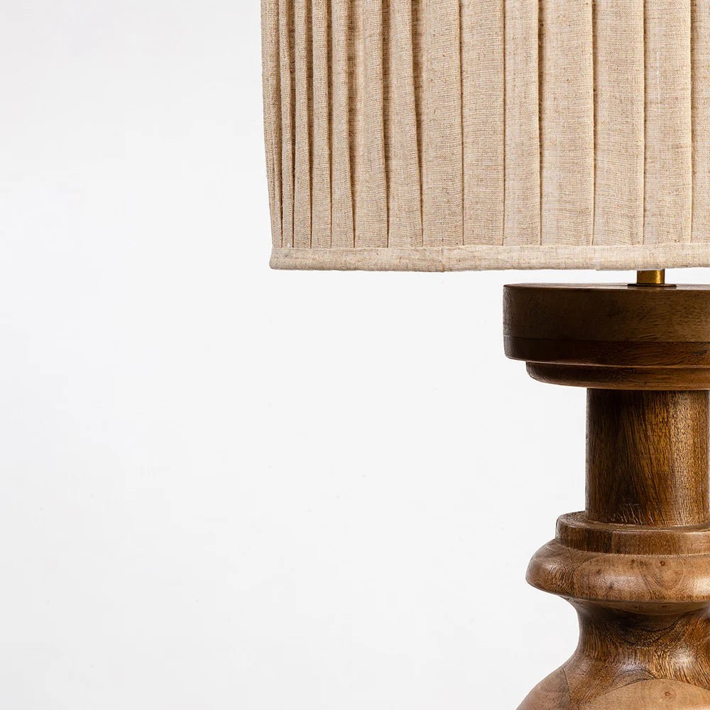 Wooden lamp with a pleated beige lampshade on a white background