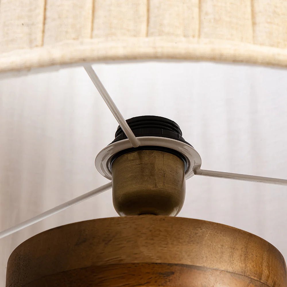 Close-up of a wooden lamp with a beige lampshade on a white background