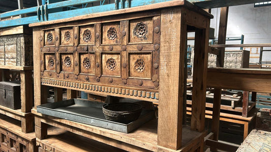 Wooden cabinet with intricate carvings in a storage or display setting