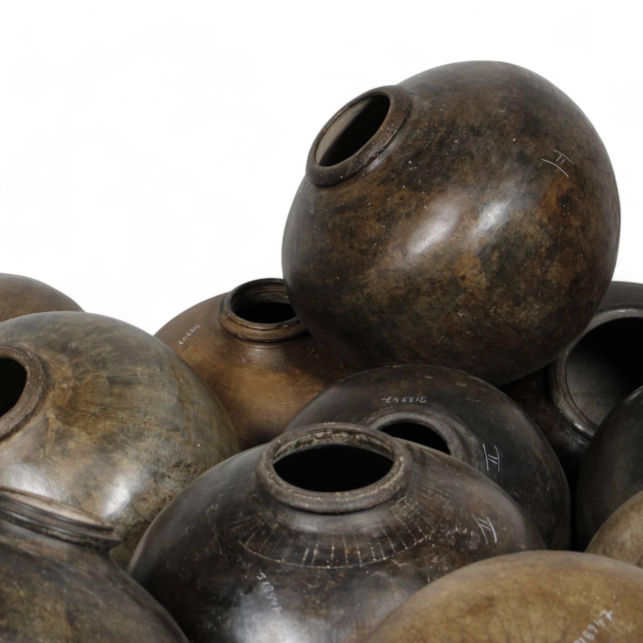 Side view of large antique clay pot with dark natural finish displaying traditional craftsmanship