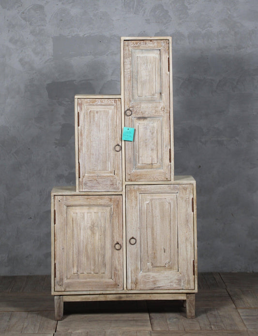 Stack of wooden cabinets against a gray wall