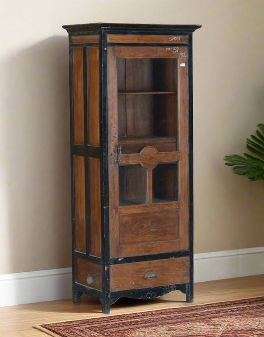 Wooden display cabinet with black accents against a beige wall