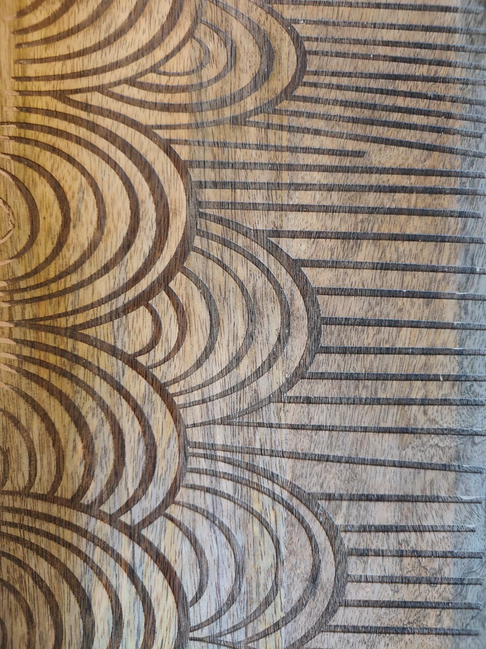 Close-up of a wooden surface with engraved wave patterns