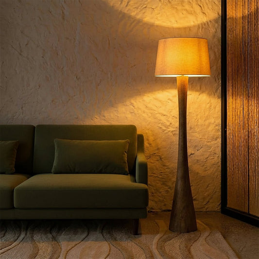Cozy room with a textured wall, beige sofa, and tall floor lamp casting warm light.