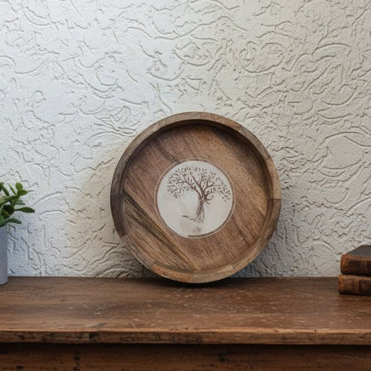 Wooden tray with tree design on a textured wall background