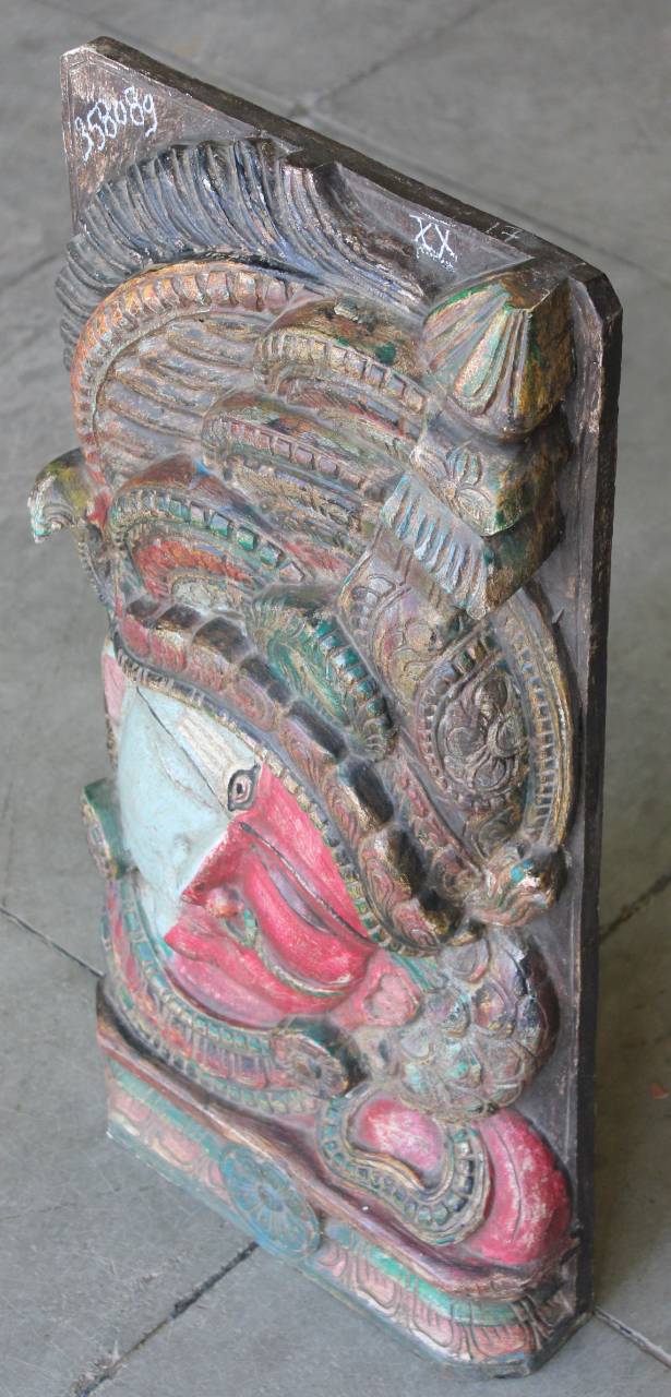 Carved wooden sculpture of a dragon or similar creature on a gray surface