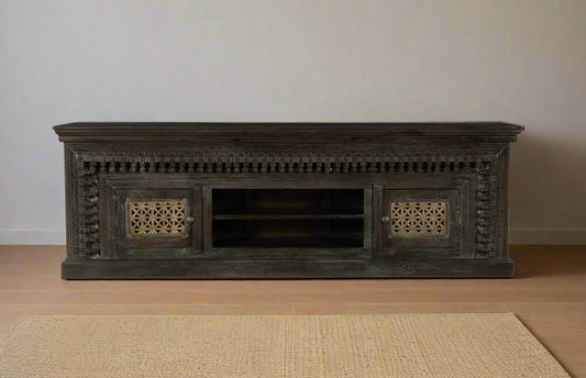 Dark wooden TV stand with intricate carvings on a white background
