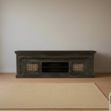 Dark wooden TV stand with intricate carvings on a white background