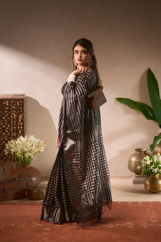Woman in a black and white checkered dress standing in a room with decorative elements.