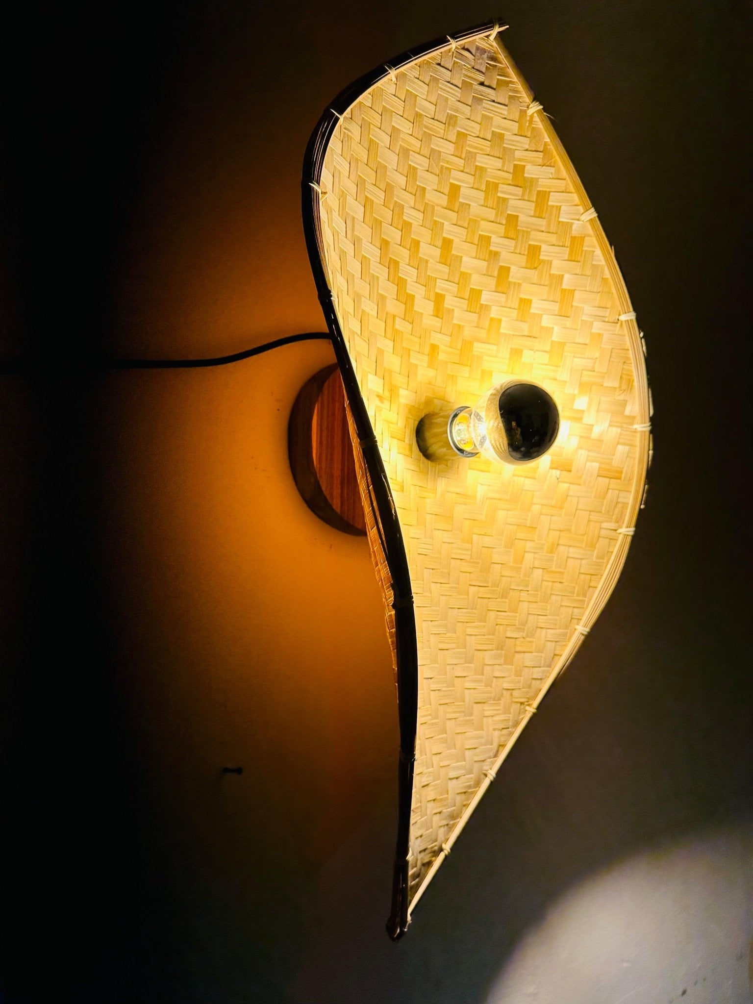 Bamboo curve wall light switched on casting warm light in styled room – Tesu Lamps & Lighting