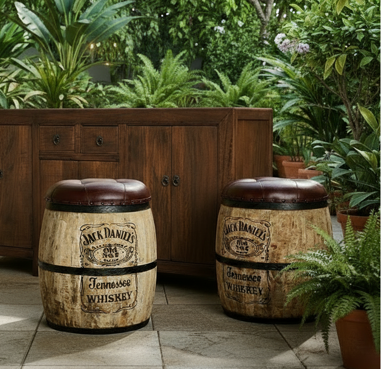 Two Jack Daniel's whiskey barrel stools in an outdoor setting with plants and a wooden cabinet.