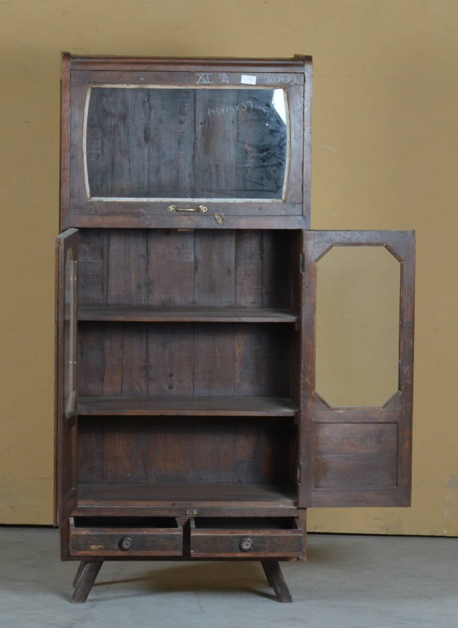 Wooden bookshelf with glass door and open doors against a beige wall.