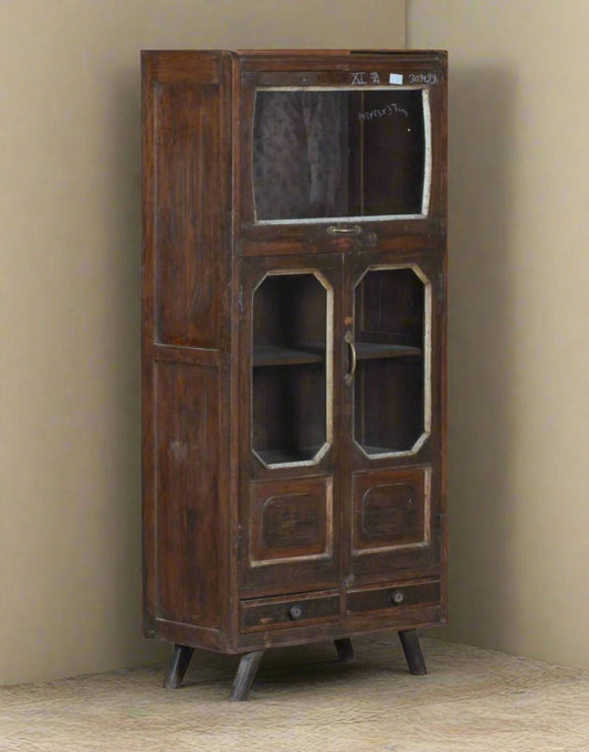 Vintage wooden cabinet with glass doors against a beige wall.