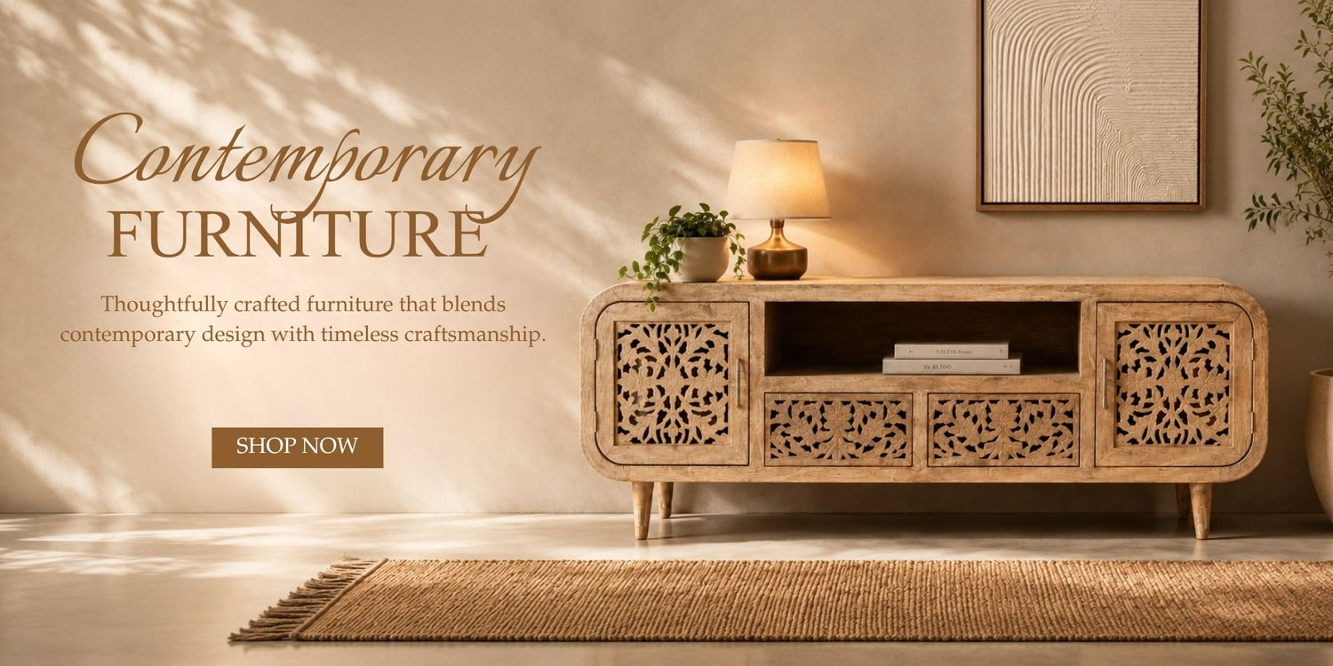 A light natural wood contemporary media console with intricate laser-cut floral patterns on the doors, styled in a warm, sunlit room with a lamp, small plant, and framed wall art.