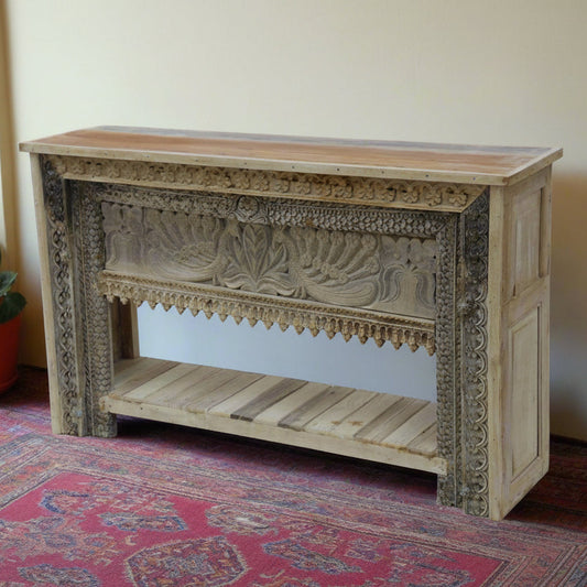 Wooden console table with intricate carvings on a patterned rug